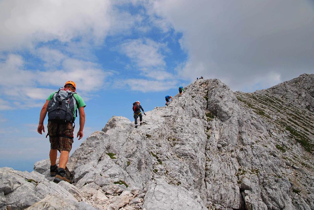 skupina turist� stoup� h�ebenem k vrcholu